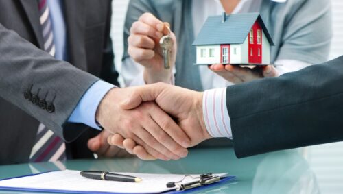 Estate agent shaking hands with customer after contract signature peabody ma